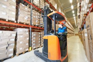 warehouse forklift stacker loader stacking cardboxes in storehouse